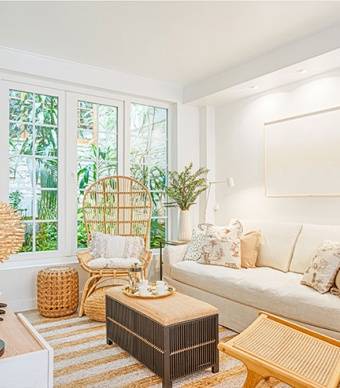 Sala com pavimento cerâmico com efeito de madeira, tapete natural às ricas brancas e cadeira de jardim em madeira